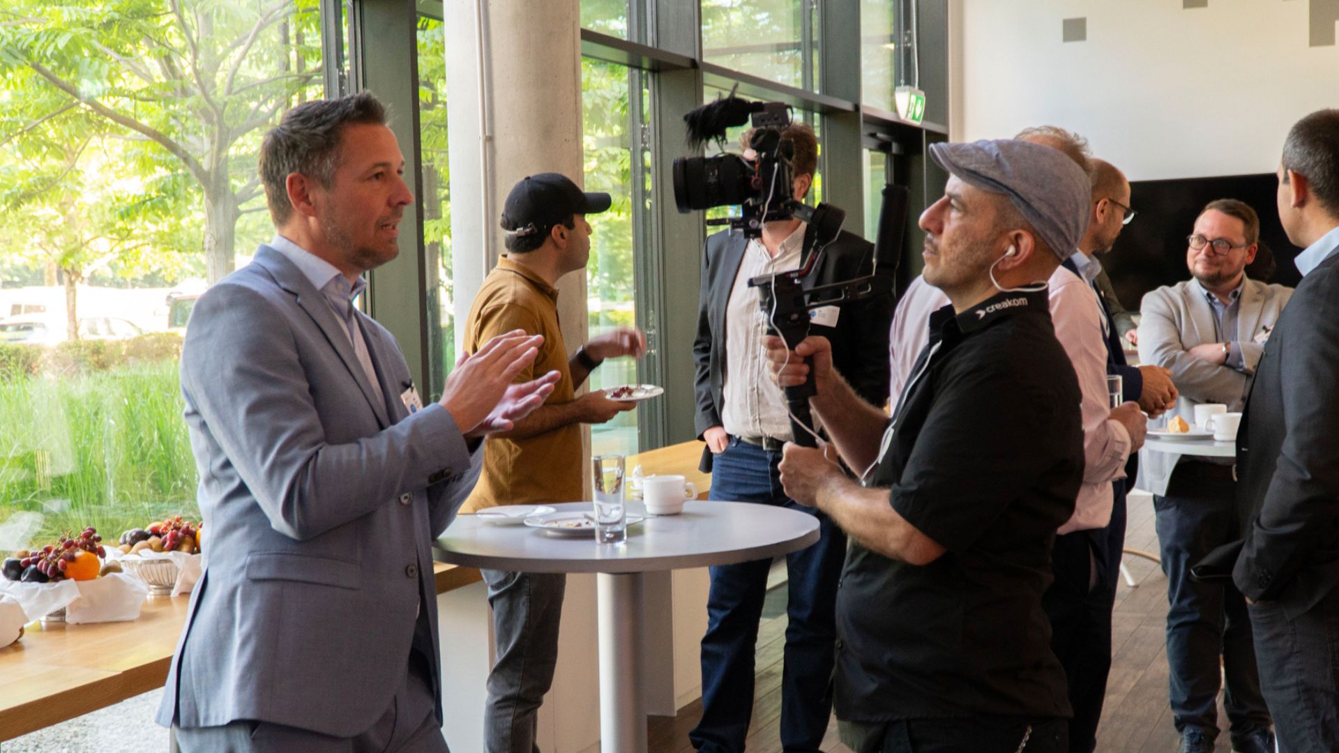 Kameramann mit Gimbal-Kamera filmt Gäste bei einem Empfang